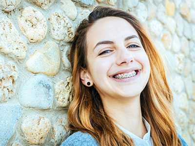 young adult girl smiling with braces