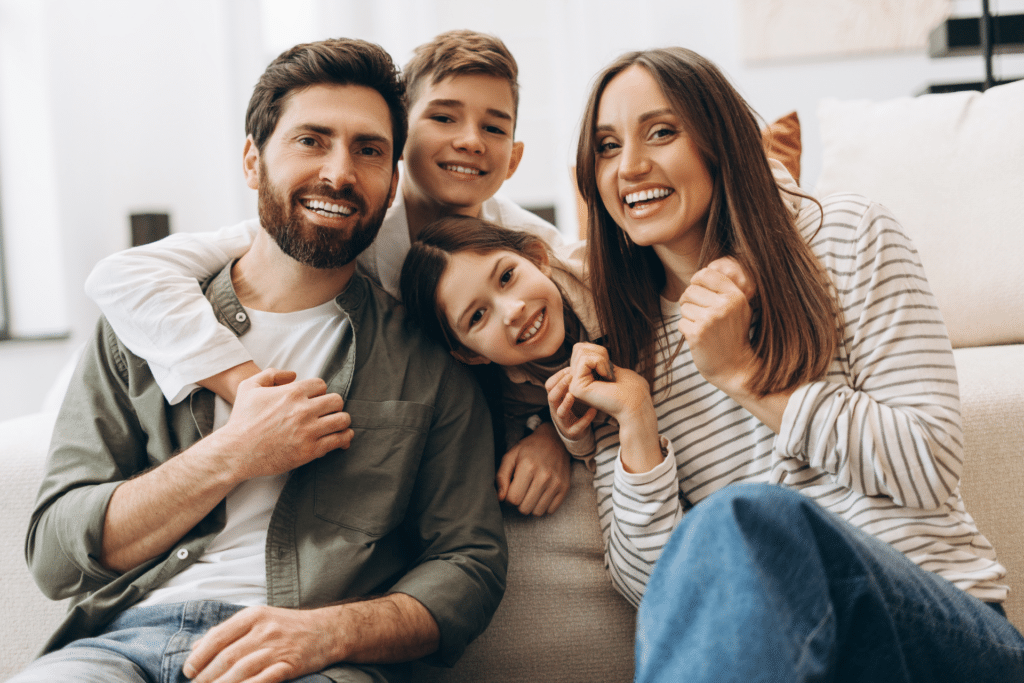 Family smiling together while considering when to start braces in Ann Arbor MI
